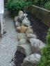 Boulder Retaining Wall to solve drainage situation with neighbor